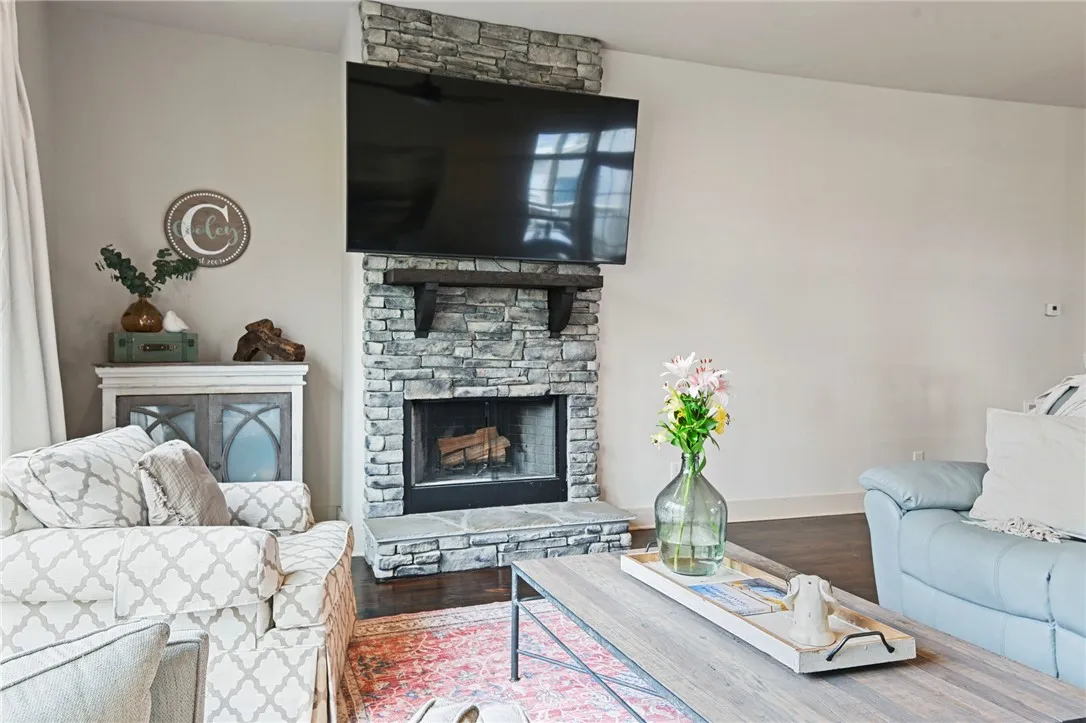 A commanding stone fireplace with a substantial hearth grounds this comfortable living area.