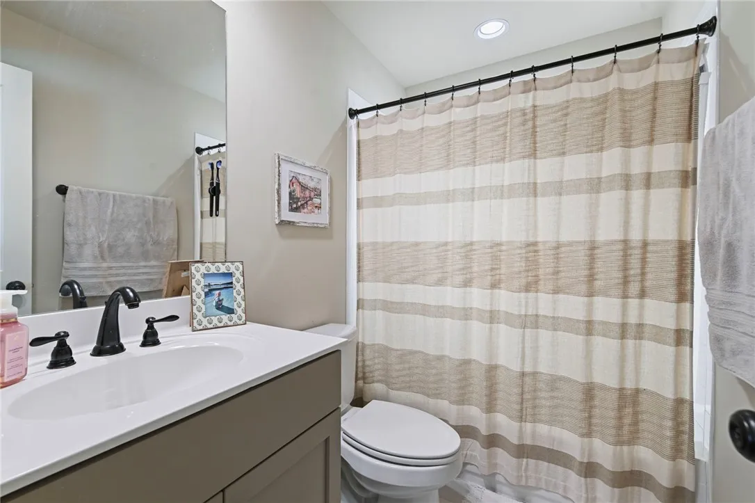 A well-appointed bath features a sleek vanity, modern fixtures, and a clean, functional design.