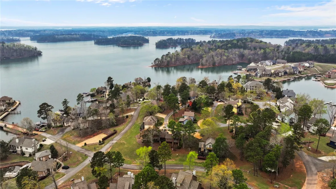 An aerial perspective reveals a serene waterfront community nestled amidst lush, tree-lined shores.