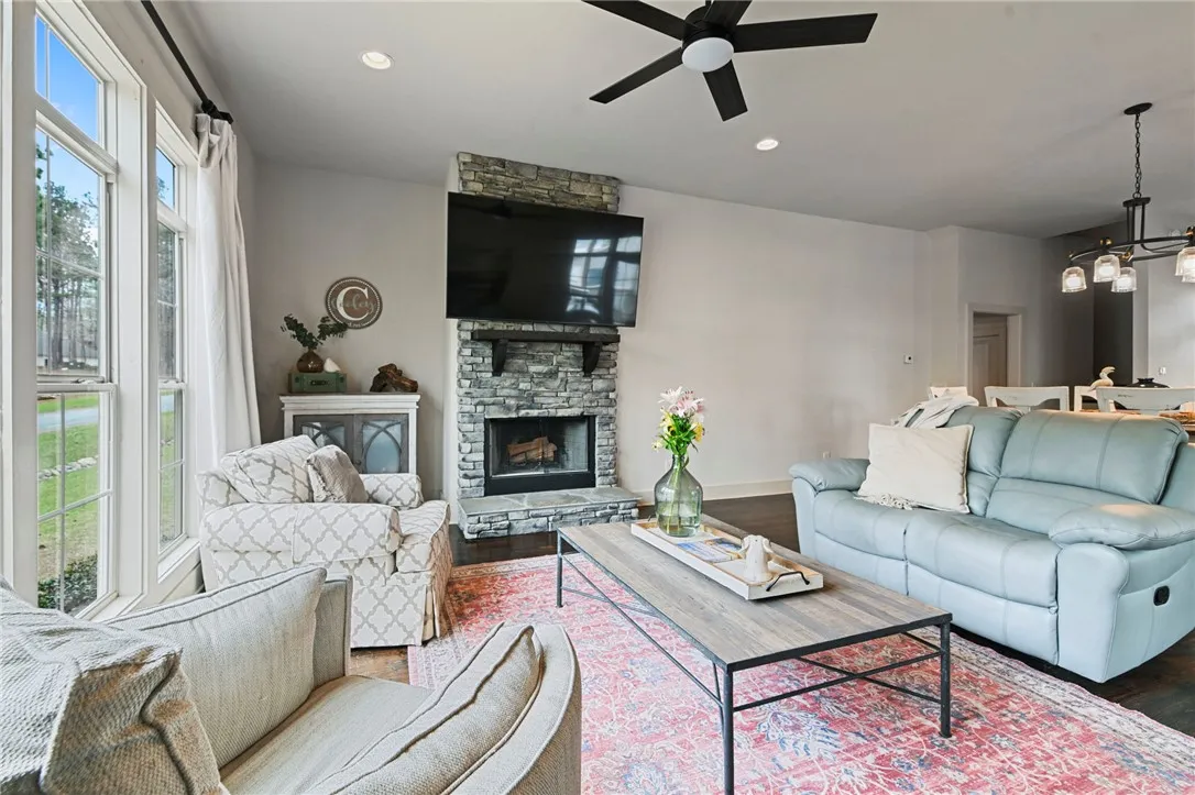 A stone fireplace anchors this inviting great room, offering a warm focal point and ample natural light.