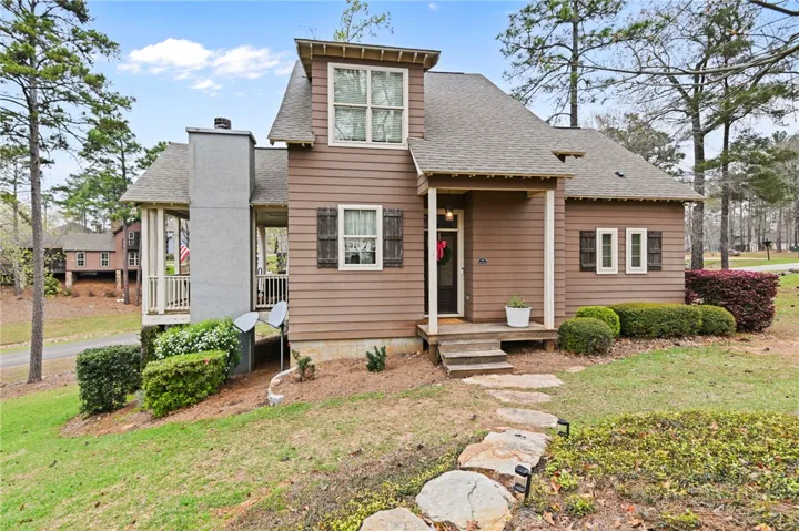 A charming exterior with a natural wood finish, accented by stone steps leading to the inviting entrance.