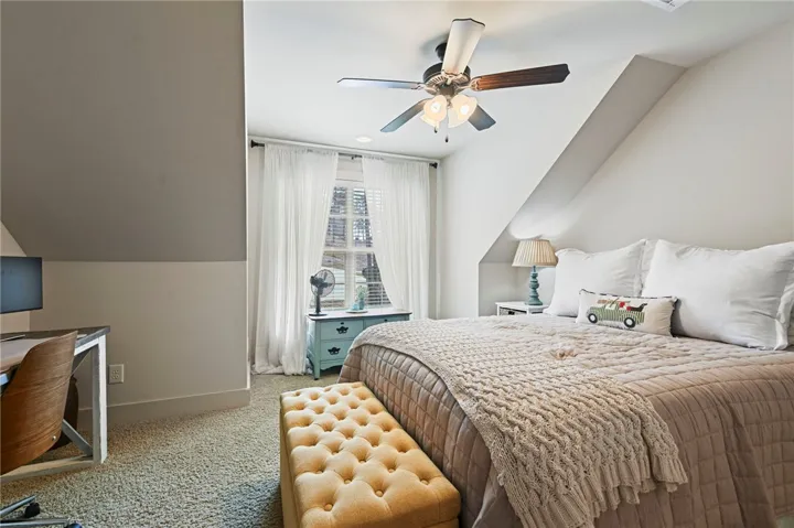 Comfortable bedroom retreat with sloped ceilings and ample natural light.