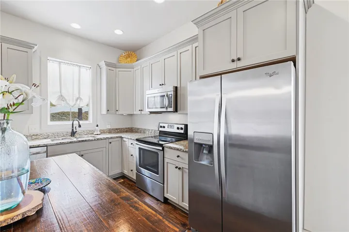 Granite counters and stainless steel appliances adorn this well-appointed kitchen.