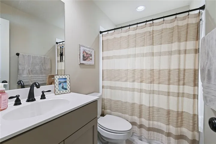 A well-appointed bath features a sleek vanity, modern fixtures, and a clean, functional design.