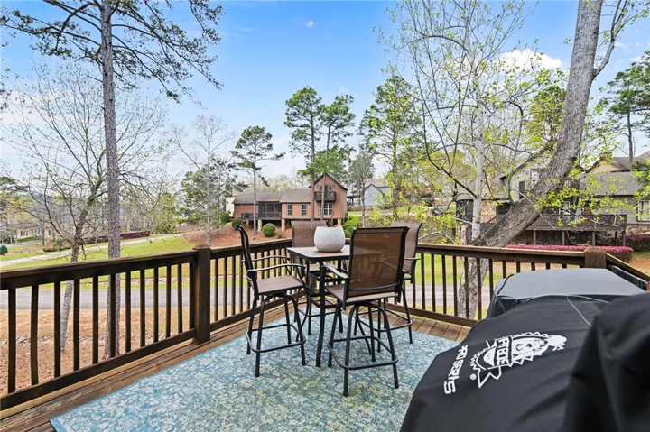 Unwind on this spacious wood deck, offering views of the surrounding natural landscape and distant homes.