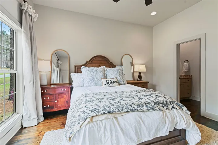 A window-lit bedroom features hardwood floors and a convenient adjoining bath.