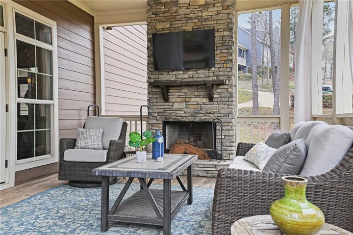 A screened porch boasts a stone fireplace for cozy evenings and tranquil outdoor living.