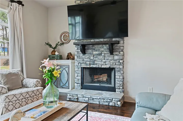 A striking stone fireplace hearth anchors this inviting living space.