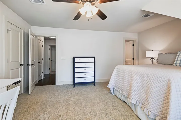 A well-lit bedroom features plush carpet and an inviting, neutral palette.