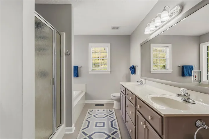 Primary bath has a stand alone shower, double vanity and a soak tub.