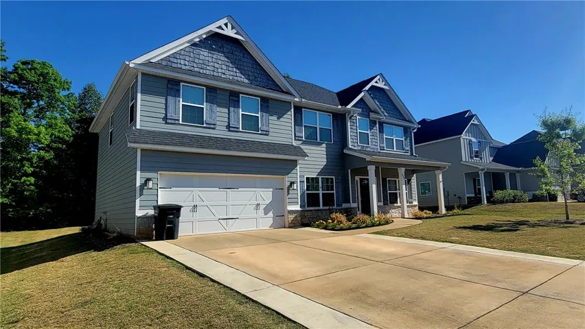 This charming residence features a well-maintained exterior and a spacious driveway.
