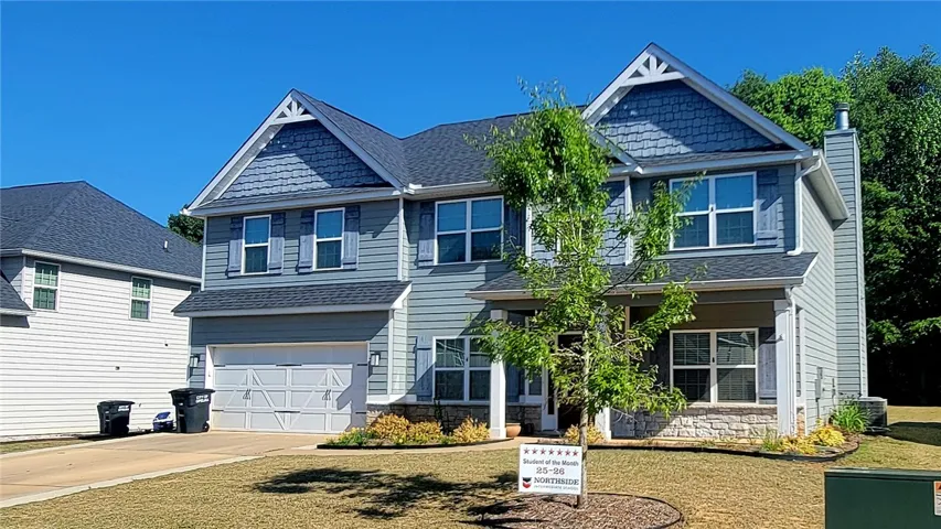 This charming home offers a traditional design with a welcoming facade and mature landscaping.