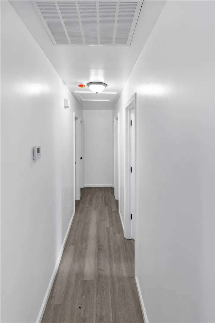 This clean and inviting hallway features elegant hardwood flooring, guiding you through a bright, functional space.