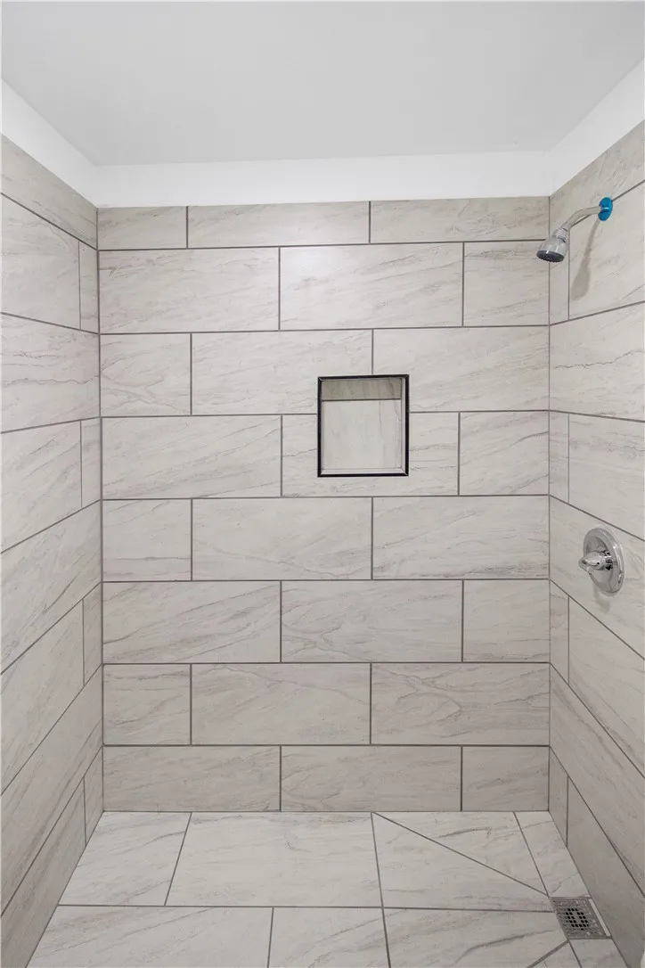 This sleek shower features modern tile work and a built-in niche for convenience.