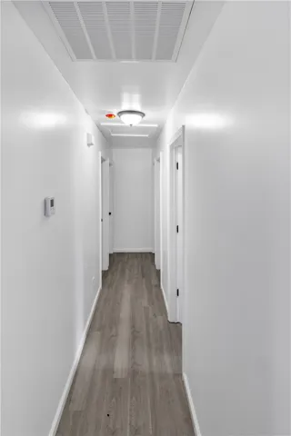 This clean and inviting hallway features elegant hardwood flooring, guiding you through a bright, functional space.