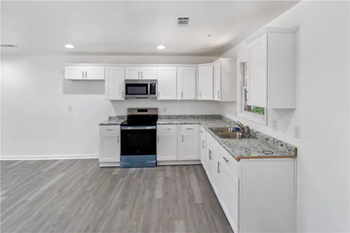 This modern kitchen features crisp white cabinetry and sleek countertops, offering a clean and inviting space.