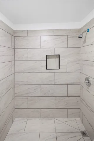 This sleek shower features modern tile work and a built-in niche for convenience.