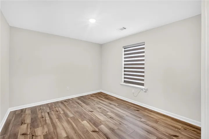Well-lit room featuring durable LVP flooring and modern window treatments.