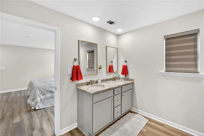 Double vanity with granite counters provides ample space in this well-appointed bathroom.