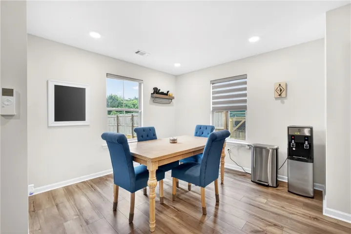 This naturally illuminated dining space boasts rich LVP flooring and generous windows overlooking the private yard.