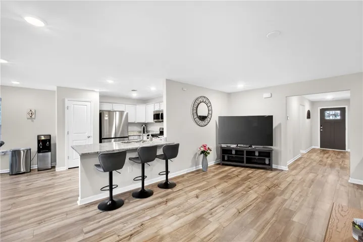 An open concept living area boasts resilient LVP flooring and a functional kitchen island for effortless entertaining.