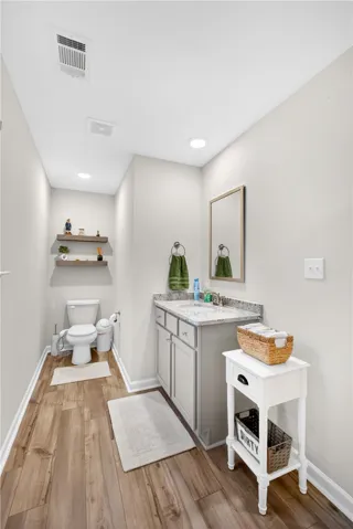 A well-appointed bathroom with durable wood-look flooring and a functional vanity.