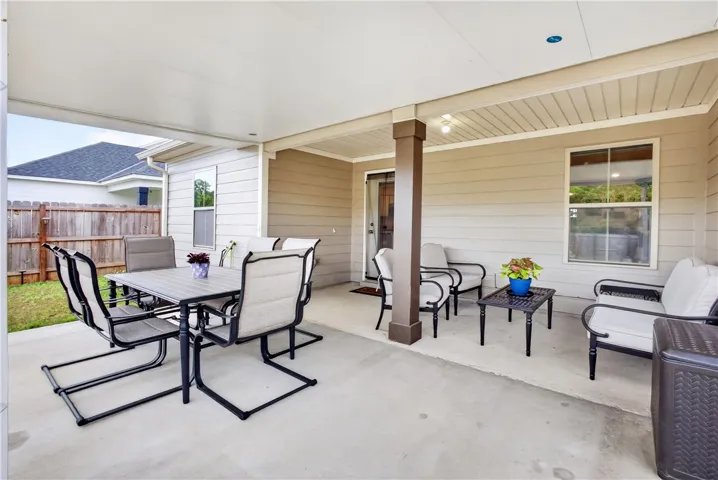 An inviting covered patio offers a comfortable space for outdoor dining and relaxation.