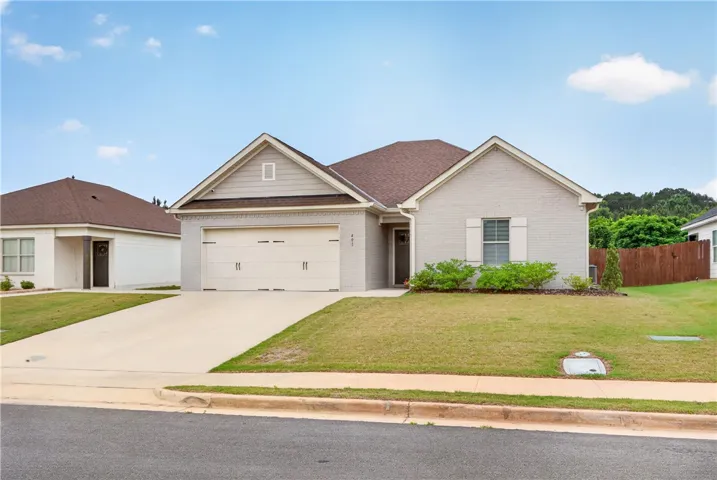 A classic ranch home features a neatly manicured lawn and an attached two-car garage.