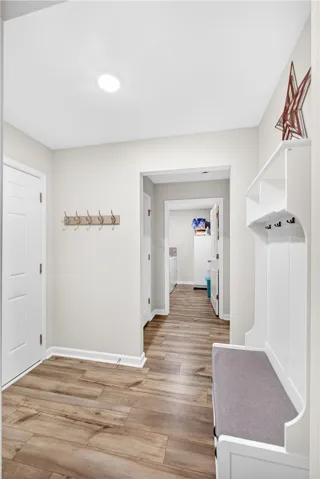 A well-lit entry hall features durable LVP flooring and practical storage solutions.