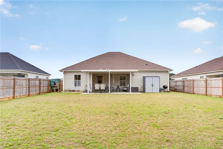 A spacious, fenced backyard perfect for entertaining, with a covered patio for outdoor living.