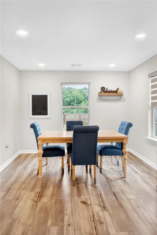 LVP floors and a sun-drenched window define this intimate dining space.