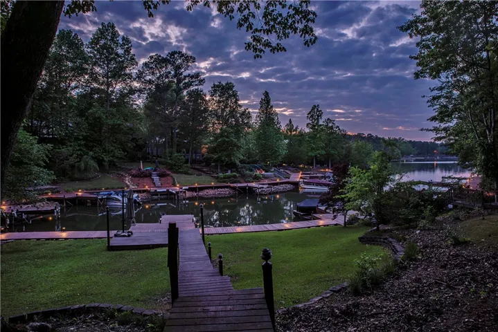 This serene lakefront property boasts a private dock, offering direct water access under a dramatic sky.