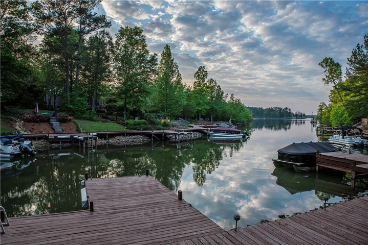 This serene waterfront property boasts expansive wooden docks and lush green surroundings under a vast sky.