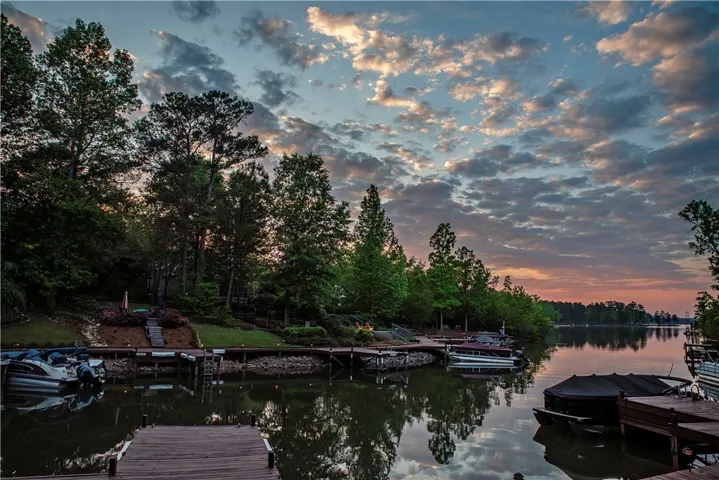 This serene waterfront property boasts direct lake access and private boat docks under a captivating sky.