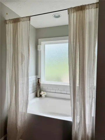 Relax in a soaking tub with an adjacent window, complete with subtle privacy.