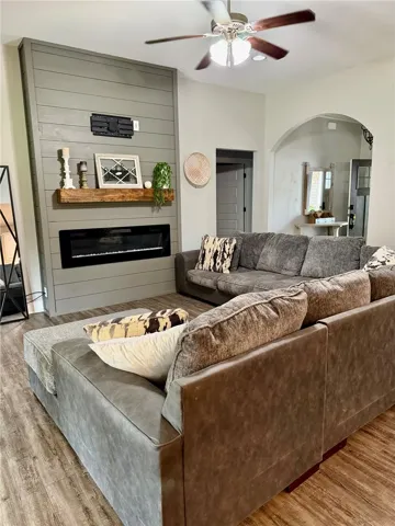 A striking fireplace feature wall with a rich wood mantel anchors this inviting living space.