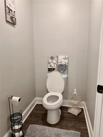 Hardwood-style flooring and a simple toilet create a functional powder room.