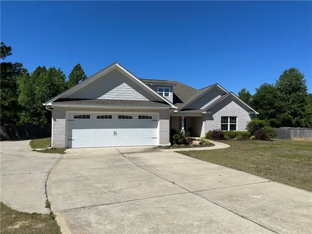 This charming home offers a spacious concrete driveway leading to an attached garage.