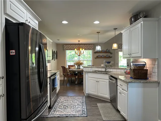 Bright and inviting kitchen with granite counters and rich wood flooring, perfect for culinary adventures.