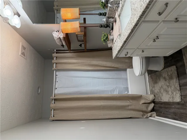 Granite counters and a clean vanity elevate daily routines in this well-appointed bathroom.