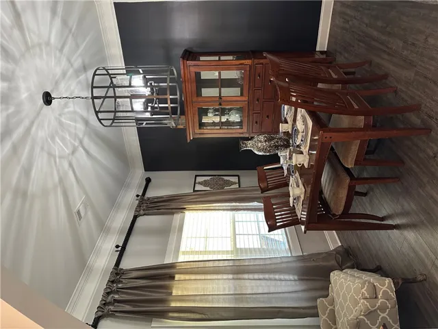 This elegant dining room features rich wood flooring and crown molding, creating an inviting atmosphere for meals.