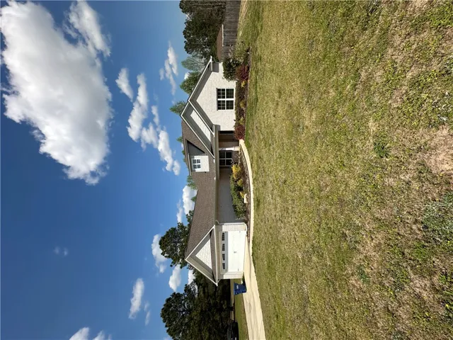 This charming home offers a spacious front yard and a classic brick exterior.