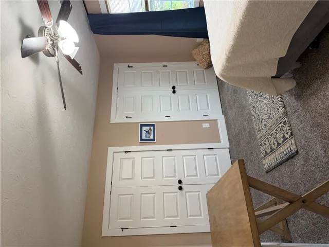 Well-lit room featuring ample closet space and plush carpeting for ultimate comfort.
