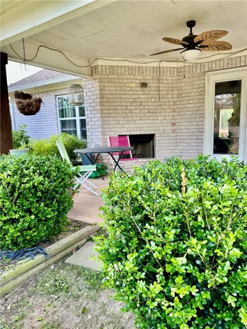 Enjoy outdoor living on this welcoming patio, featuring a brick fireplace
