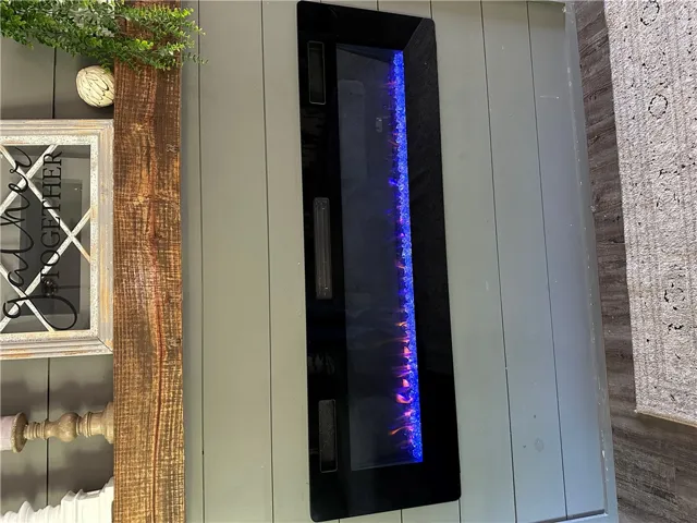 This living room boasts a sleek electric fireplace, adding a contemporary focal point.