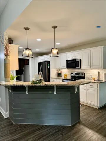 Granite counters and recessed lighting elevate this modern kitchen design.