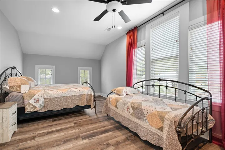 Bedroom 3 is a spacious, light-filled room with multiple windows and a walk-in closet for ample storage.