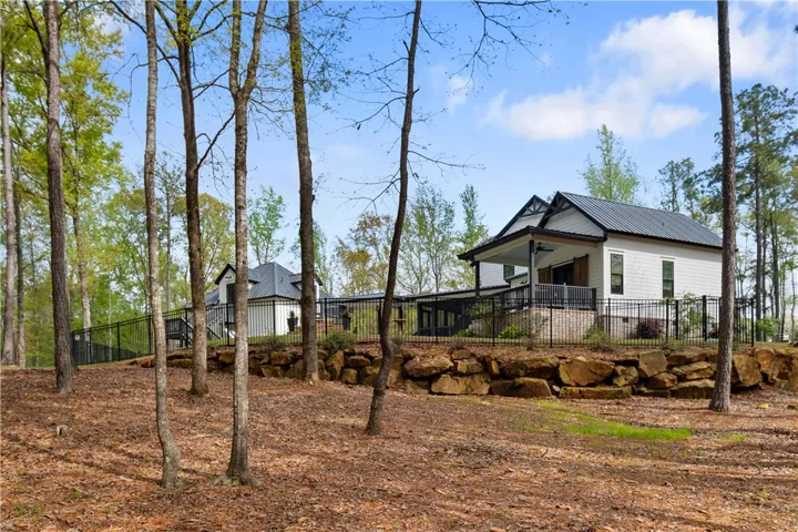 A stone retaining wall is positioned just beyond the fence.