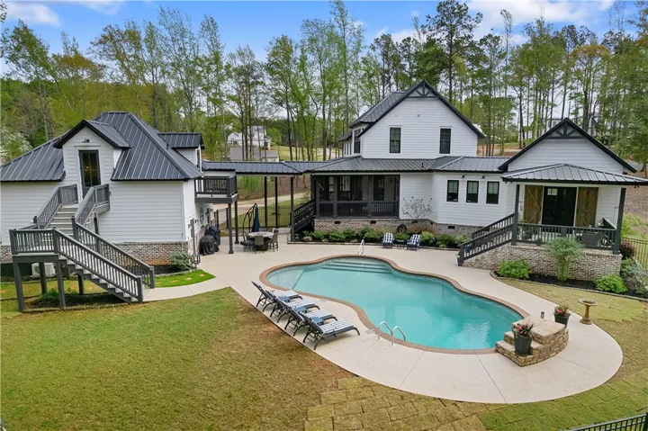 A rare offering with a beautifully appointed main residence, three-car garage with fully equipped apartment, resort-style pool, & acreage.