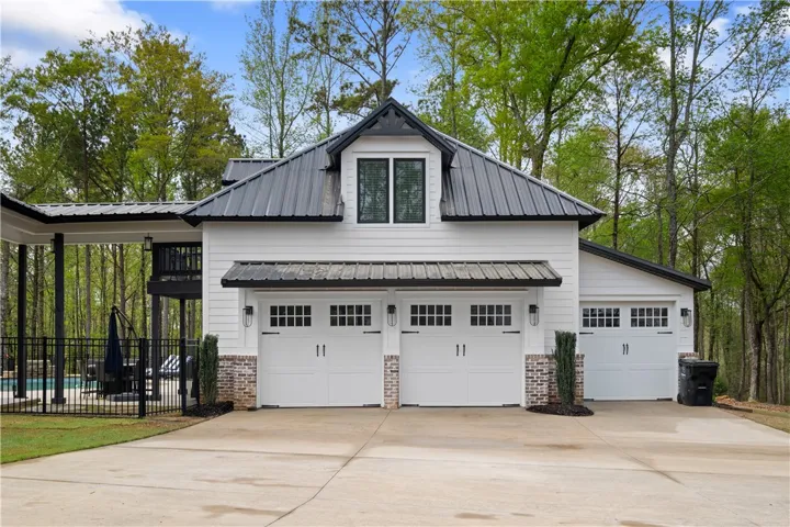 The three-car garage offers extensive storage, along with a full bath for the pool and a fully equipped apartment above.